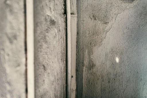 Close-up of damp, water-damaged concrete wall texture.